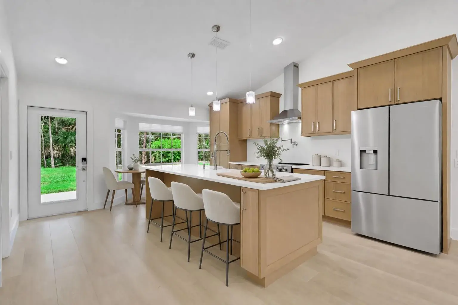 New white-oak kitchen island with quartz countertop in a completed Naples, Florida renovation